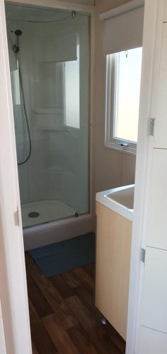 une salle de bain avec une douche, une baignoire et un lavabo dans l'établissement MH135 camping TOHAPI NOVELA - Mobil home 5p climatisé -, à Port-la-Nouvelle