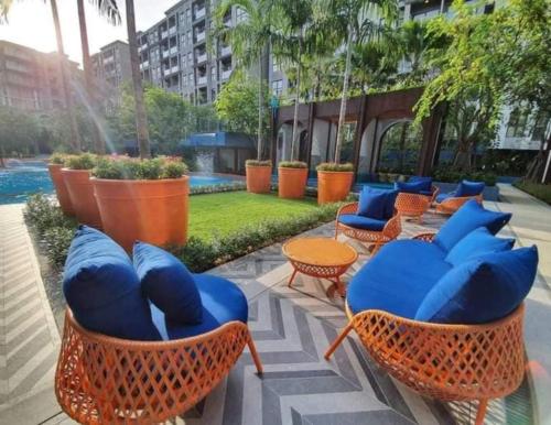 a patio with blue chairs and tables and a pool at La Habana HuaHin by Pikul in Khao Tao