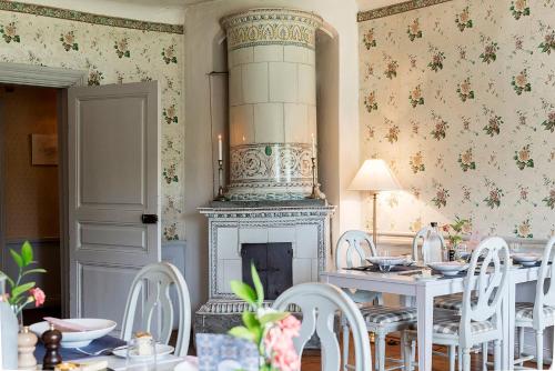 a dining room with a fireplace and a table and chairs at Krusenberg Herrgård in Krusenberg