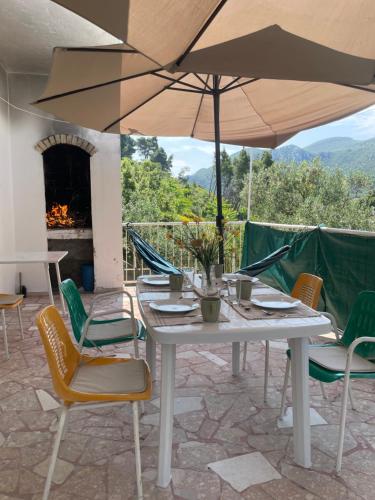 a white table with chairs and an umbrella on a patio at Holiday house“Tonka” in Žuljana