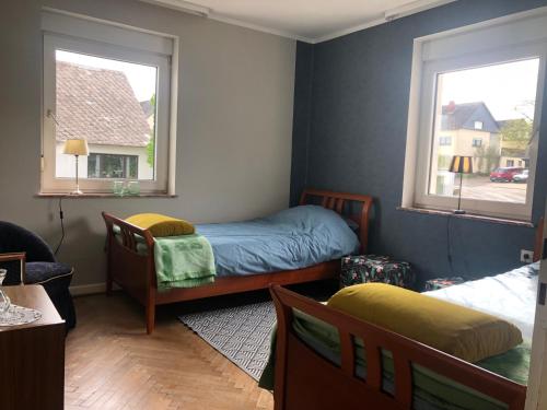 1 dormitorio con 1 cama, 1 silla y 2 ventanas en Ferienhaus Dommersch25, en Dommershausen