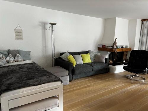 a living room with a bed and a couch at 2.5 Zimmer Wohnung Davos Platz in Bolgen