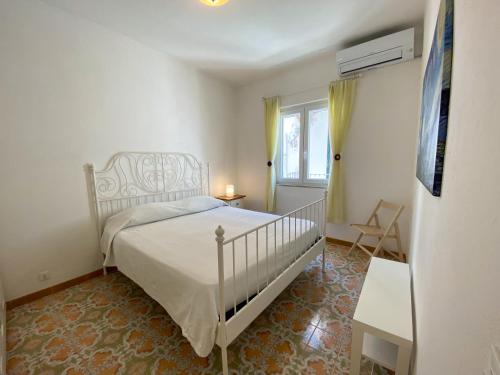 una camera con un letto bianco e una finestra di Casetta Chiaia a Ischia