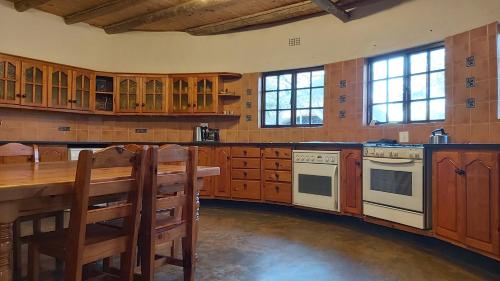 a large kitchen with wooden cabinets and a wooden table at Izintaba Private Game Reserve Waterberg in Vaalwater