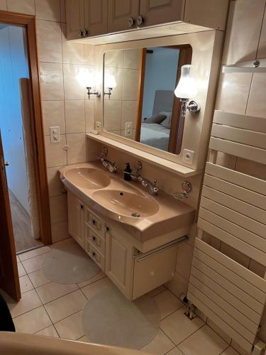 La salle de bains est pourvue d'un lavabo et d'un miroir. dans l'établissement 2.5 Zimmer Wohnung Davos Platz, à Bolgen