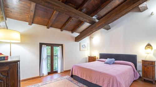 1 dormitorio con 1 cama en una habitación con techos de madera en Tenuta Contessa Chiara 17, Emma Villas, en Fontanile