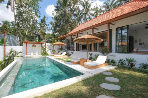 a villa with a swimming pool and a house at Villa Lestari Ubud in Tegalalang