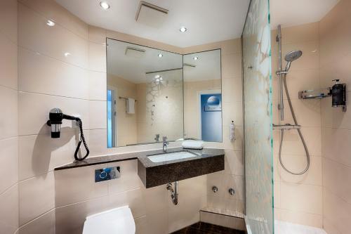ein Bad mit einem Waschbecken und einer Dusche in der Unterkunft Premier Inn Stuttgart Bad Cannstatt in Stuttgart