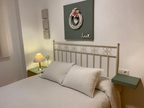 sypialnia z łóżkiem i zdjęciem na ścianie w obiekcie Apartamentos Alcañiz, Marisol w mieście Alcañiz