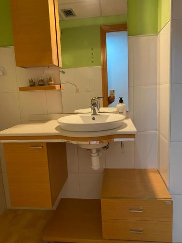 W łazience znajduje się umywalka i lustro. w obiekcie Apartamentos Alcañiz, Marisol w mieście Alcañiz