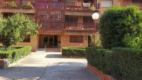 un edificio de apartamentos con balcón y pasarela en Apartamentos Alcañiz, Marisol en Alcañiz