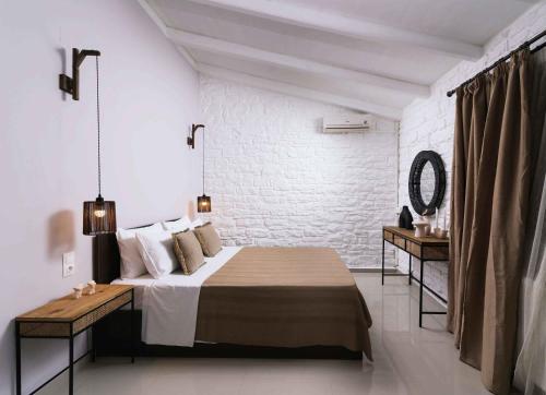 a white bedroom with a bed and a mirror at Villa Repsimia with Private Jacuzzi in Kókkinos Pírgos