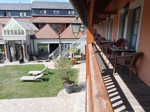 a balcony of a house with chairs and a patio at Hotel et Spa Le Lion d'Or in Pont-lʼÉvêque