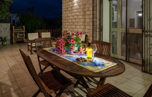 a wooden table with flowers and candles on a patio at Casa vacanze "Ulivi nel Mare" in Sciacca