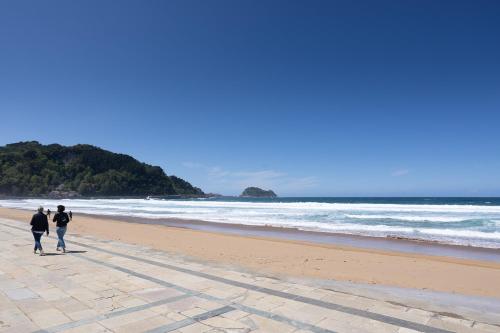 two people walking on the beach at Egona-SAN LUIS 2 Vivienda, playa y garaje in Zarautz