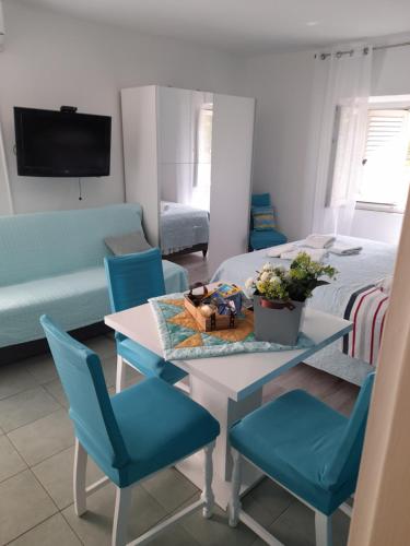 a living room with a table and blue chairs at Apartment Filomena in the center in Komiža