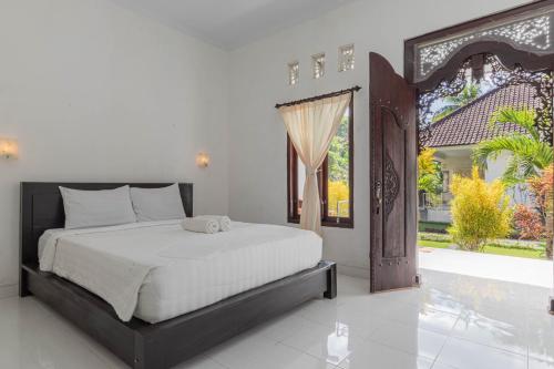 1 dormitorio con cama y ventana grande en Nyuh Kadah Guest House, en Nusa Penida