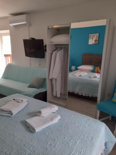 a bedroom with a mirror and a bed and a couch at Apartment Filomena in the center in Komiža