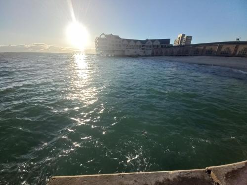 a view of the ocean with the sun reflecting on the water at Royal Classico Getaway in Strand Beach in Cape Town