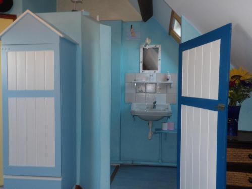 ein Badezimmer mit Tür und Waschbecken in der Unterkunft Chambres et Tables d'hôtes à l'Auberge Touristique in Meuvaines