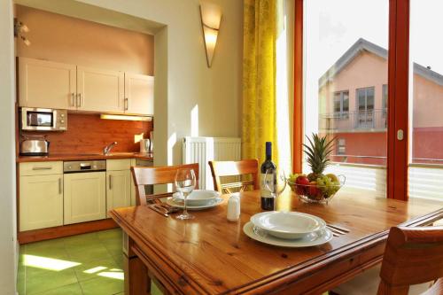 a kitchen and dining room with a wooden table at Villa Maria Wohnung 08 in Ostseebad Koserow