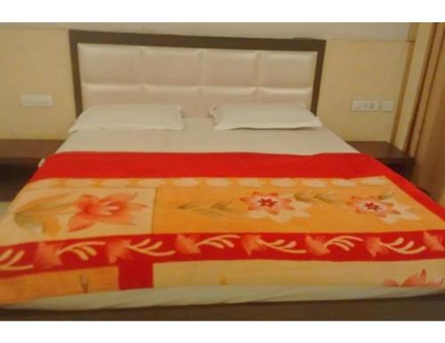 a bed with a red and white blanket on it at Hotel The Bay Inn, Konark in Pānchagān