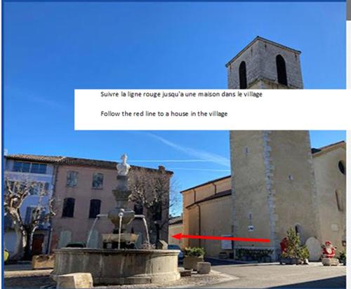 une photo d'un bâtiment avec une statue à côté d'une fontaine dans l'établissement Une maison dans le village, à Ribiers
