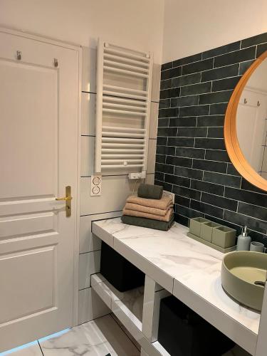 une salle de bain avec un lavabo et un miroir dans l'établissement Maison au bord de l'eau et au calme pour les vacances, à Saint-Denis-de-Pile