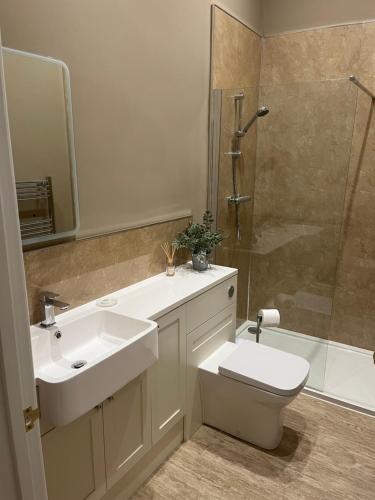 ein Bad mit einem Waschbecken, einem WC und einer Dusche in der Unterkunft The Mulberry Apartment at Langford Hall in Newark upon Trent