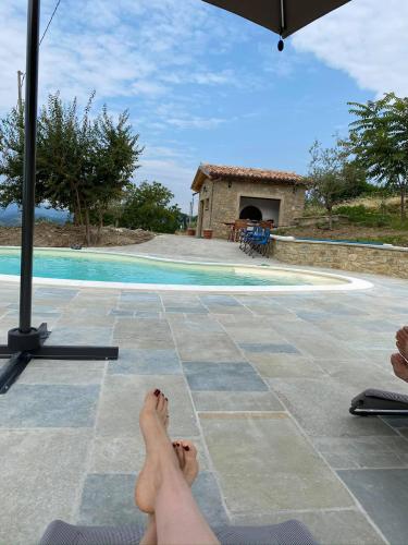 a person laying on a patio next to a swimming pool at Casa Tincana in Bebbio
