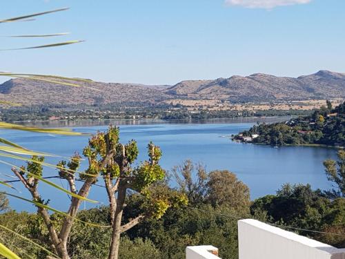 a view of a lake with mountains in the background at El Shadai Guest House & Spa Hartbeespoort in Hartbeespoort