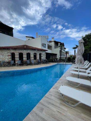 une piscine avec des chaises longues et un bâtiment dans l'établissement Samel Hotel, à Siviri