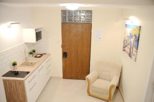 a kitchen with a wooden door and a chair at Bałtyckie-Hel in Hel