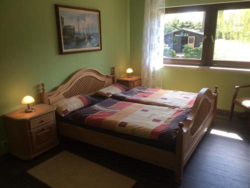 ein Schlafzimmer mit einem Bett und einem Fenster mit zwei Lampen in der Unterkunft Ferienapartment Kleist in Prerow