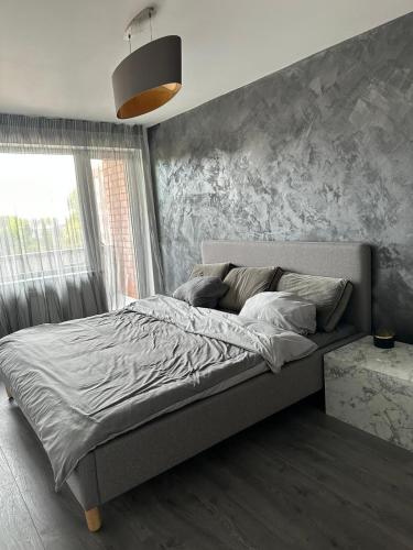 1 cama en un dormitorio con un mural en la pared en Hugo en Jēkabpils