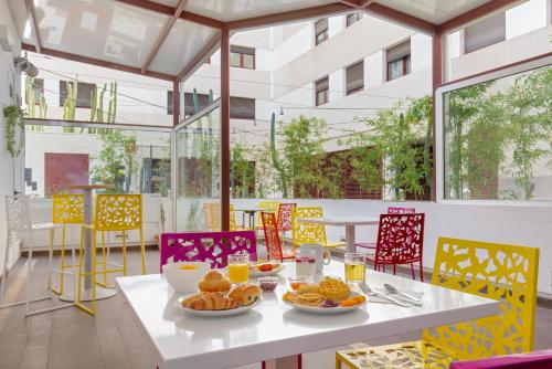 une table avec des assiettes de nourriture au-dessus dans l'établissement Novotel Suites Perpignan Centre, à Perpignan