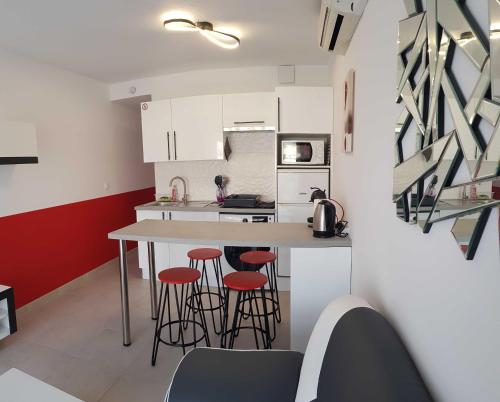 une cuisine avec un comptoir et des tabourets dans une pièce dans l'établissement Cap d'Agde Port Nature, au Cap d'Agde