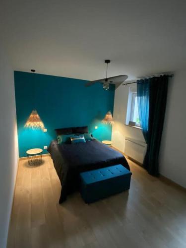 ein Schlafzimmer mit einem Bett und einer blauen Wand in der Unterkunft Escale au cœur du Vignoble Champenois in Mardeuil