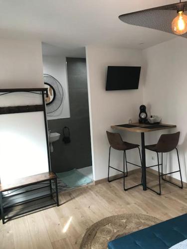 une pièce avec une table, des chaises et une télévision dans l'établissement Escale au cœur du Vignoble Champenois, à Mardeuil