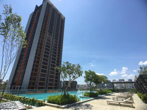 a tall building with a pool in front of it at Eco Kanvas Soho Suites in Cyberjaya