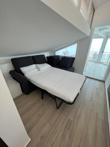 a living room with a bed and a couch at Ale Mare - Attico con idromassaggio vista mare in Marina di Ragusa