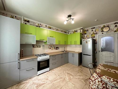 a kitchen with green cabinets and white appliances at LUZ @ Chisinau in Chişinău