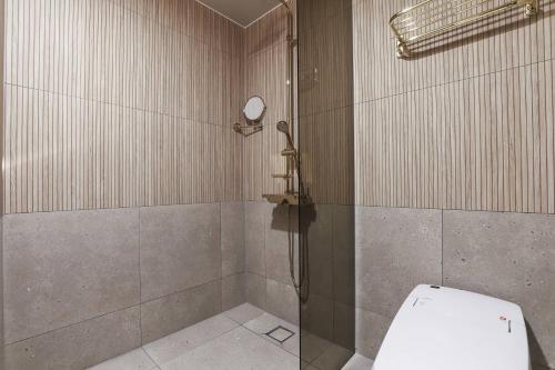 a bathroom with a shower with a toilet in it at Wonju Brown Dot Hotel Corporate city in Wonju