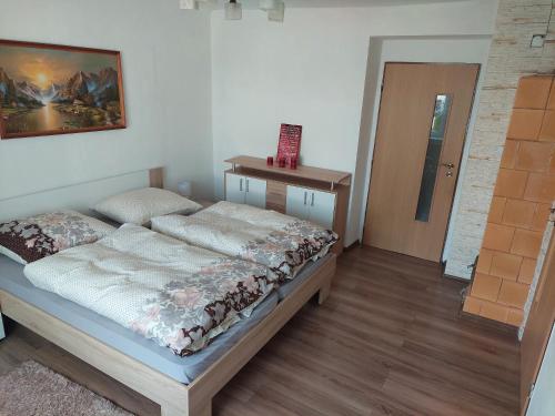 a bedroom with a bed and a wooden floor at Vaclavskeho Apartment Medzilaborce in Medzilaborce