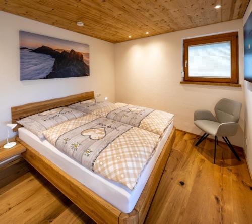 a bedroom with a bed and a chair in it at Ferienwohnung Bergnah in Pfronten