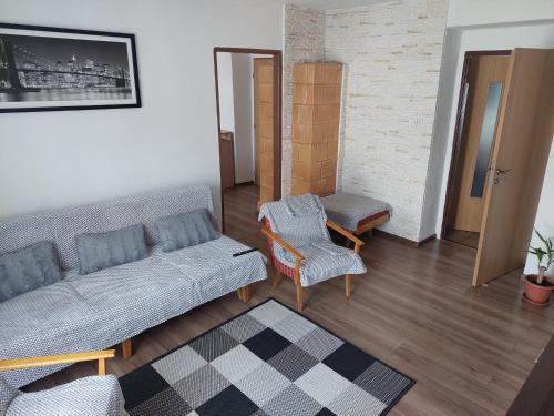 uma sala de estar com um sofá e uma cadeira em Vaclavskeho Apartment Medzilaborce em Medzilaborce