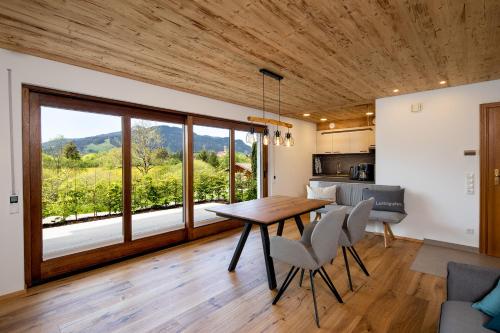 uma cozinha e sala de jantar com mesa e cadeiras em Ferienwohnung Bergnah em Pfronten