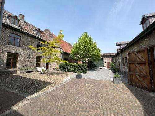 a brick walkway between two buildings with a wooden door at B&B Sjaanderhof in Maastricht