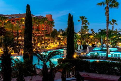 a view of the resort pool at night at Puerto Antilla Grand Hotel in Islantilla