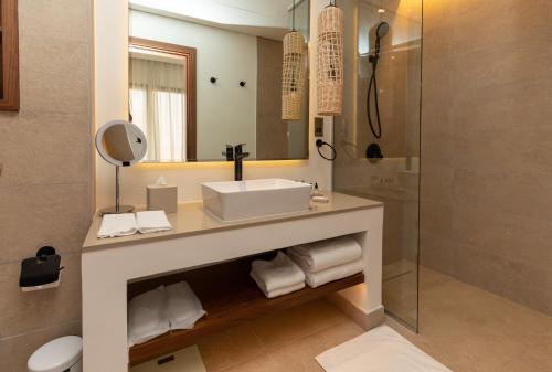 a bathroom with a sink and a mirror at Bab Al Nojoum Bateen Liwa in Liwa